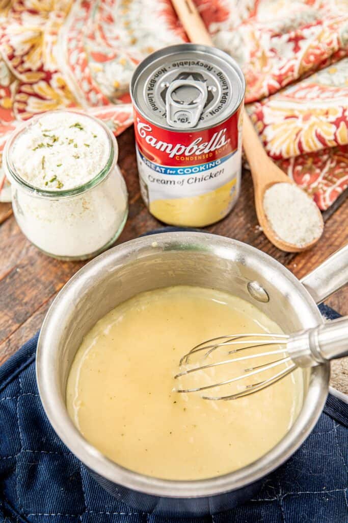 saucepan of homemade cream of chicken soup with mix, can and spoon in the background
