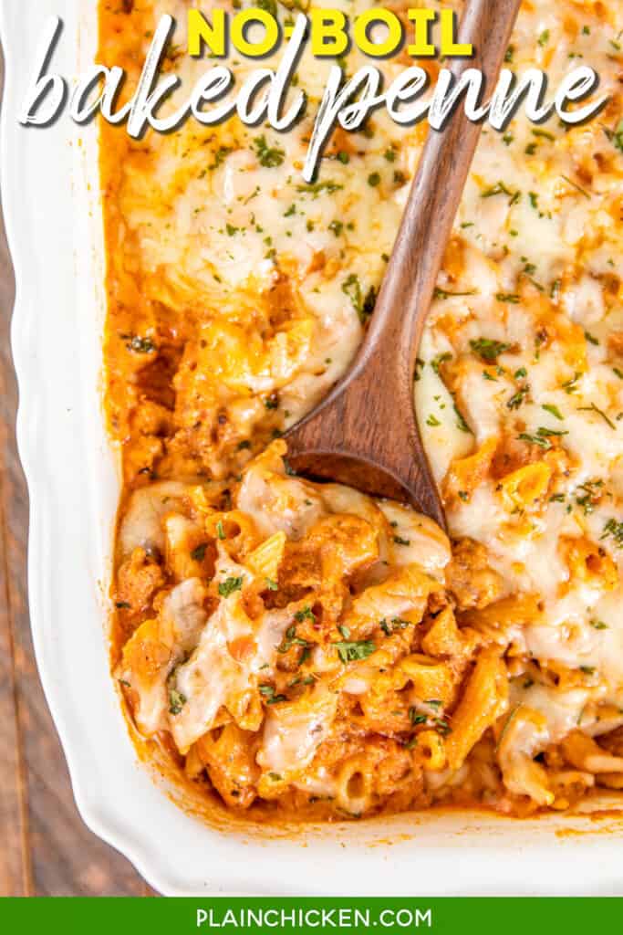 scooping baked penne pasta from casserole dish