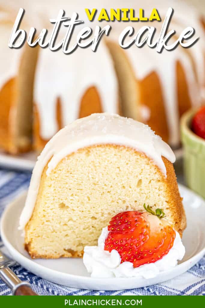 slice of iced pound cake on a plate with strawberries and whipped cream