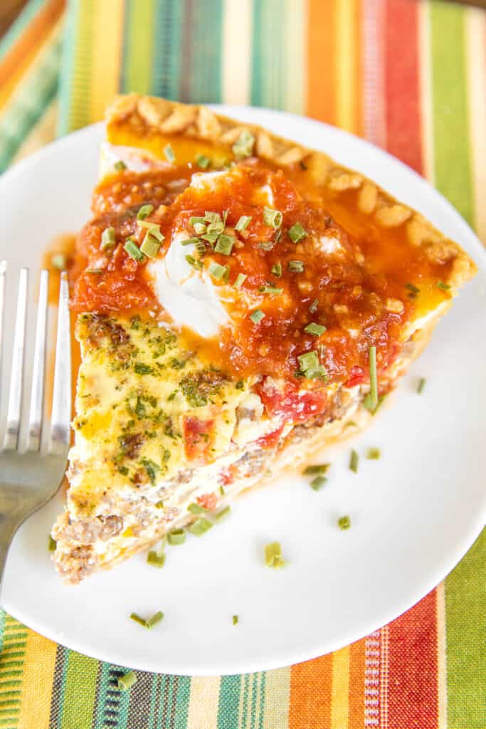 slice of quiche with sour cream and salsa on top