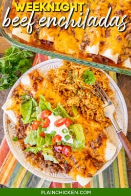 plate of beef enchiladas topped with lettuce, sour cream and tomaotes