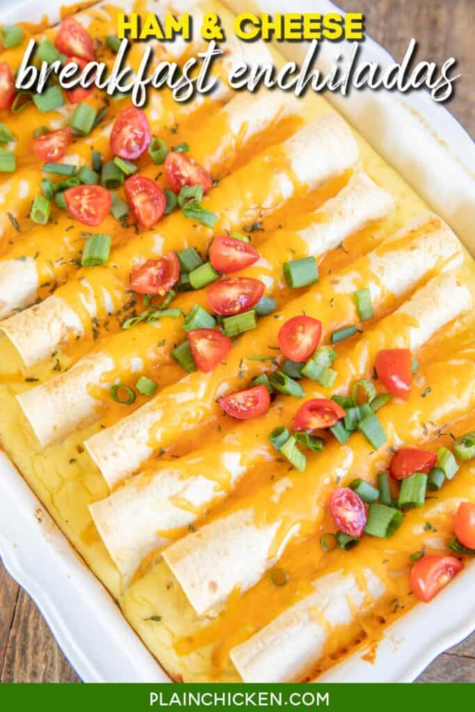 baking dish of ham & cheese breakfast enchilada casserole topped with green onions and tomatoes