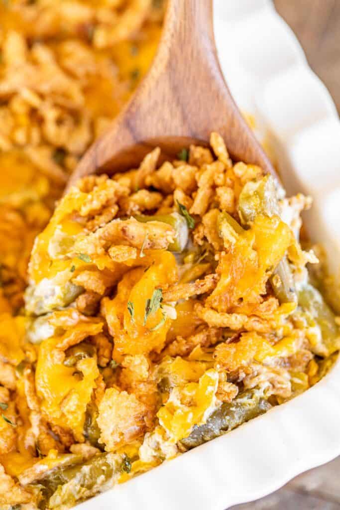 scooping french onion green bean casserole from baking dish