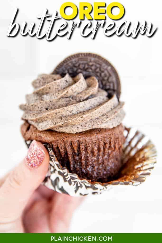 holding a chocolate cupcake with oreo buttercream frosting
