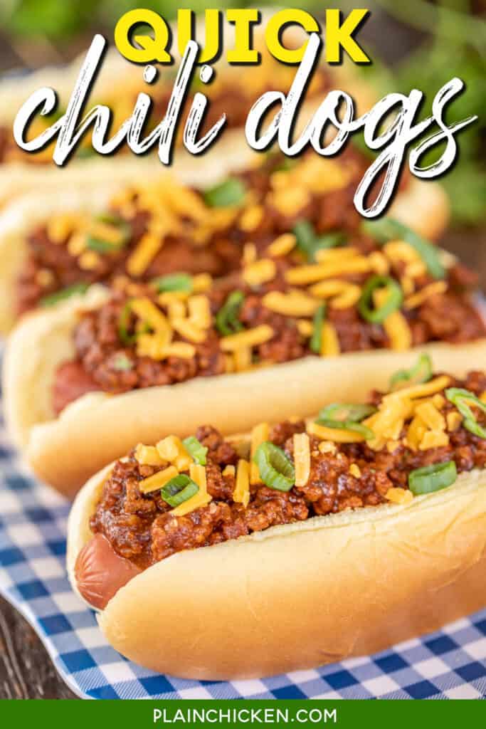 chili dogs on a platter topped with cheese and onions