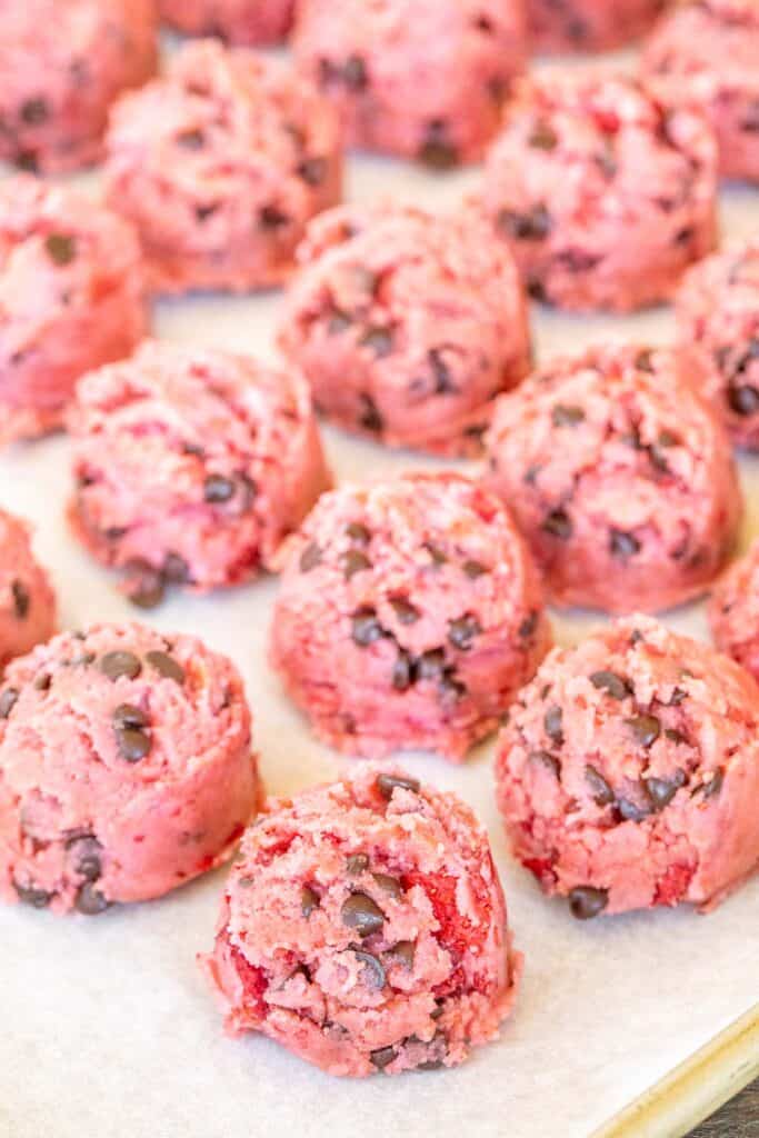 pink chocolate chip cookie dough on baking sheet