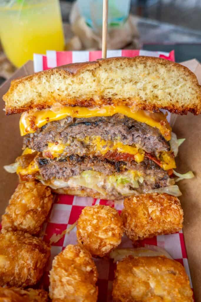 burger cut in half with tater tots
