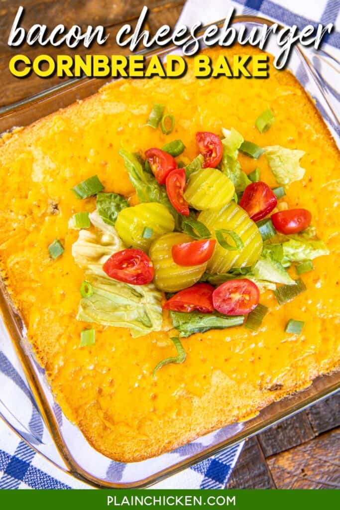 cornbread casserole in baking dish topped with lettuce tomatoes & pickles