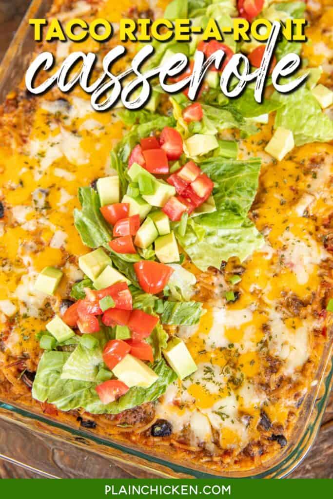 casserole dish of taco casserole topped with lettuce tomatoes and avocado