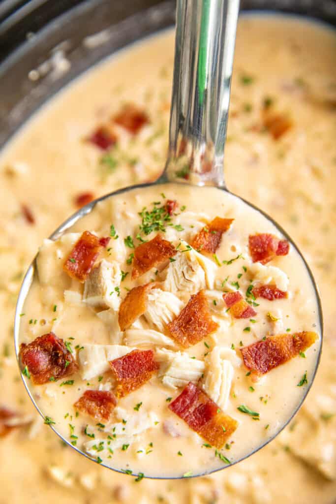 ladle of chicken potato soup topped with bacon