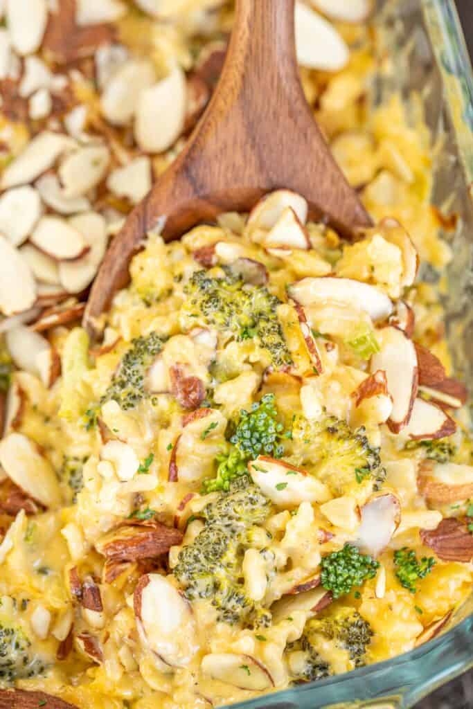 scooping broccoli rice casserole from baking dish