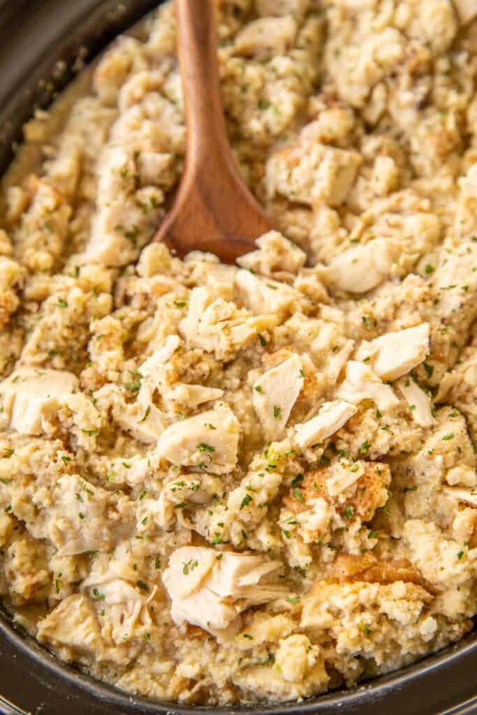 scooping chicken and dressing from slow cooker