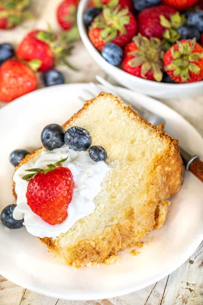slice of pound cake topped with whipped cream and berries on a plate