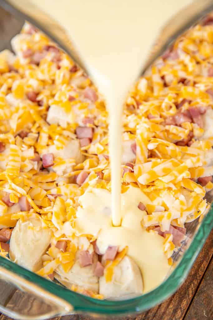 pouring egg custard over ham, cheese & biscuits