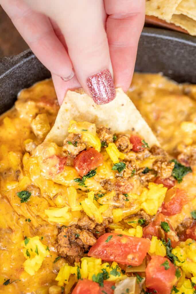 scooping nacho rice dip from skillet