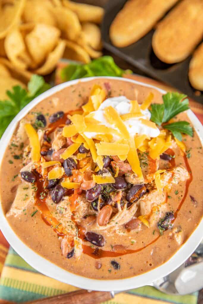bowl of chicken chili topped with sour cream and cheese