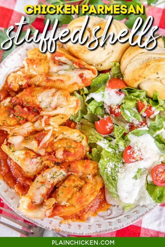 plate of chicken parmesan stuffed shells with salad and rolls