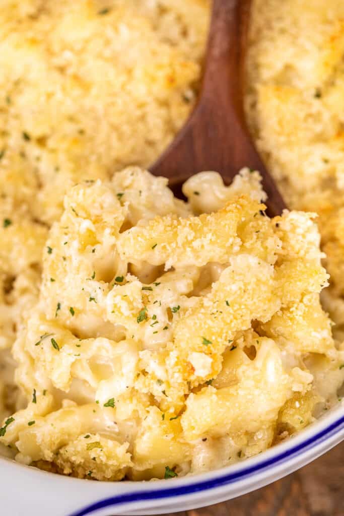 scooping steakhouse mac and cheese from baking dish
