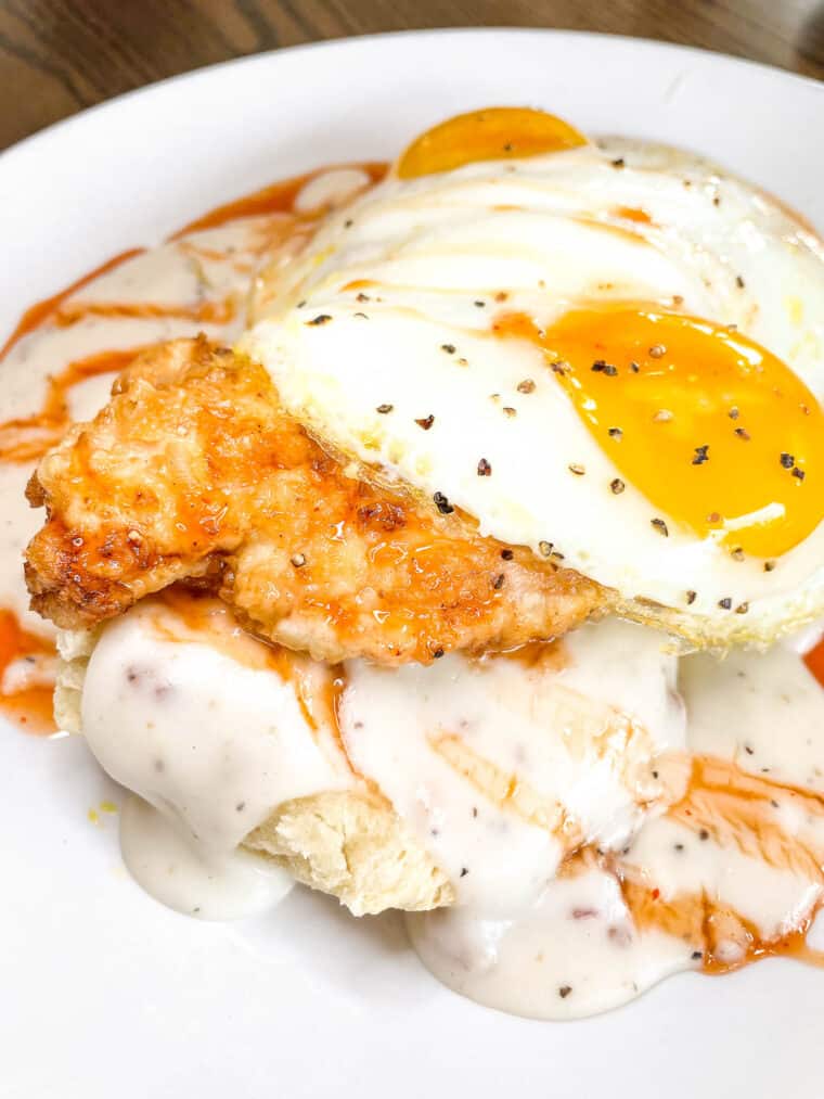 chicken biscuit and gravy topped with an egg