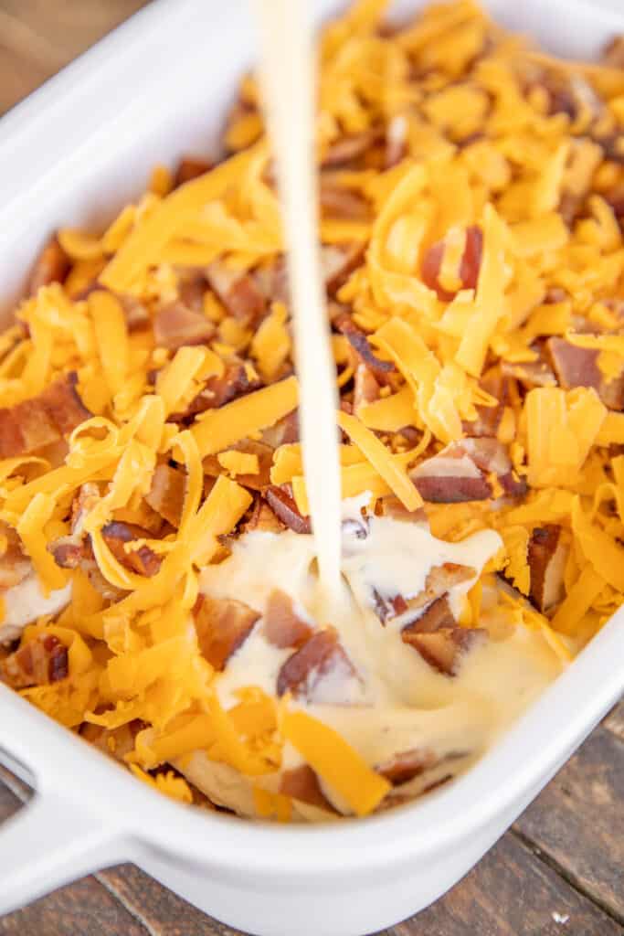 pouring egg mixture over bacon and cheese in baking dish