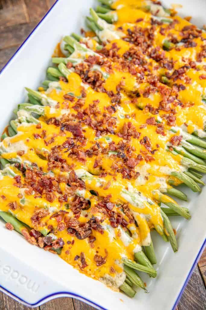 baking dish of green beans topped with cheddar and bacon