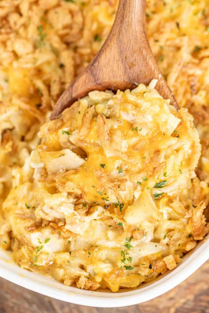 scooping chicken and rice casserole from baking dish