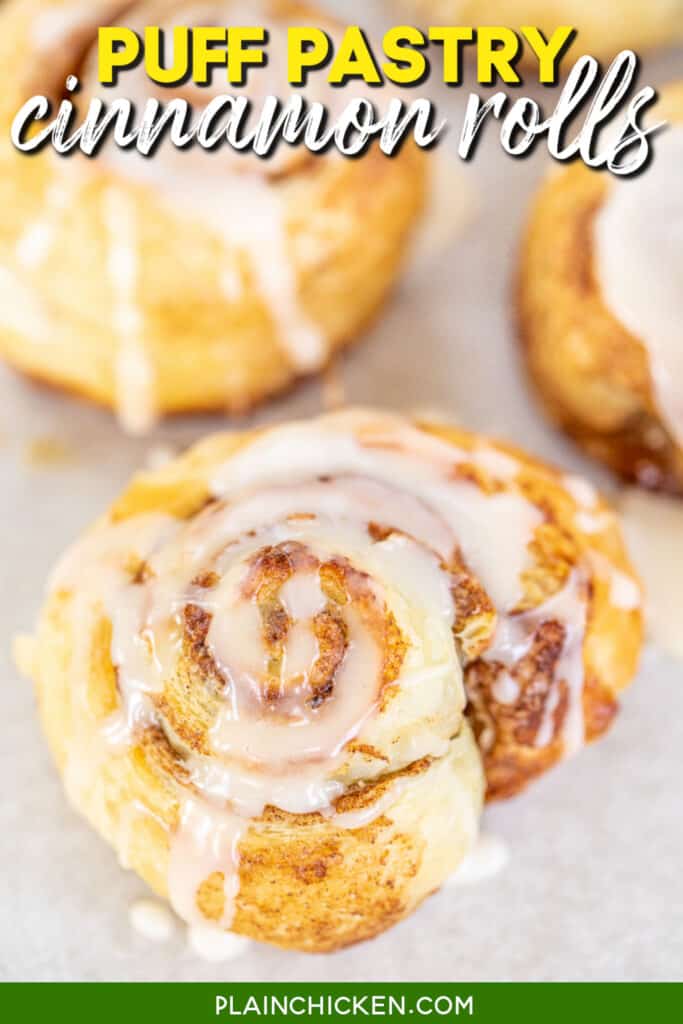 glazed puff pastry cinnamon roll on a baking sheet with text overlay