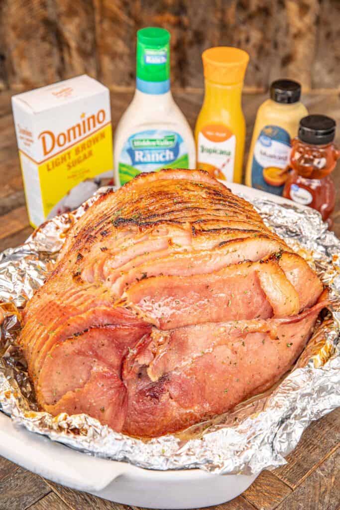 whole ham in a roasting pan with ingredients in the background