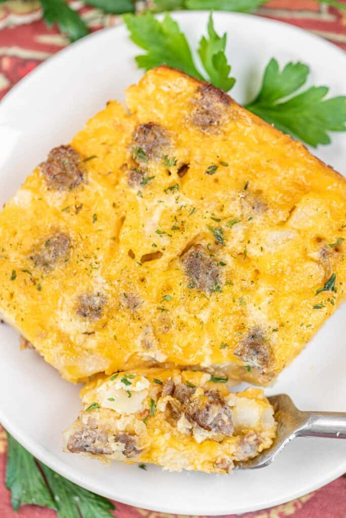 slice of sausage breakfast casserole on a plate with a fork
