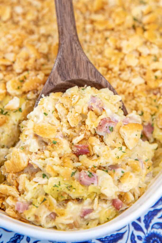 scooping chicken cordon blue rice a roni casserole from baking dish