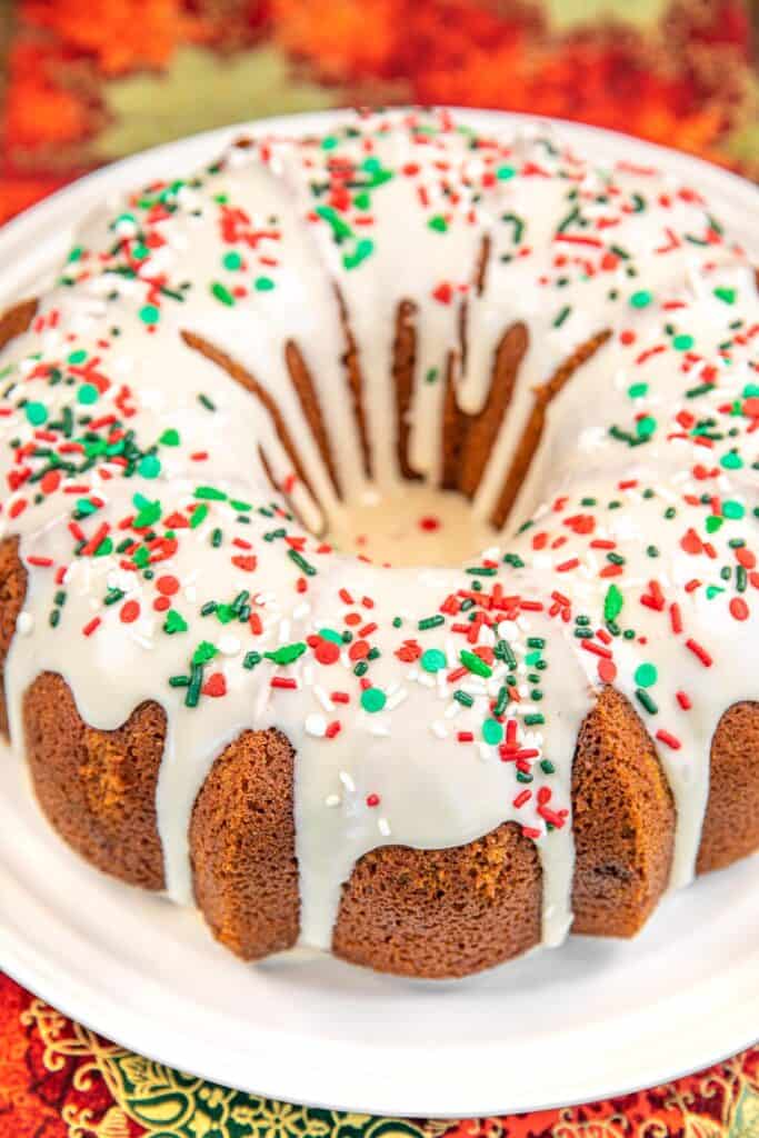 gingerbread bundt cake on a plate topped with vanilla icing