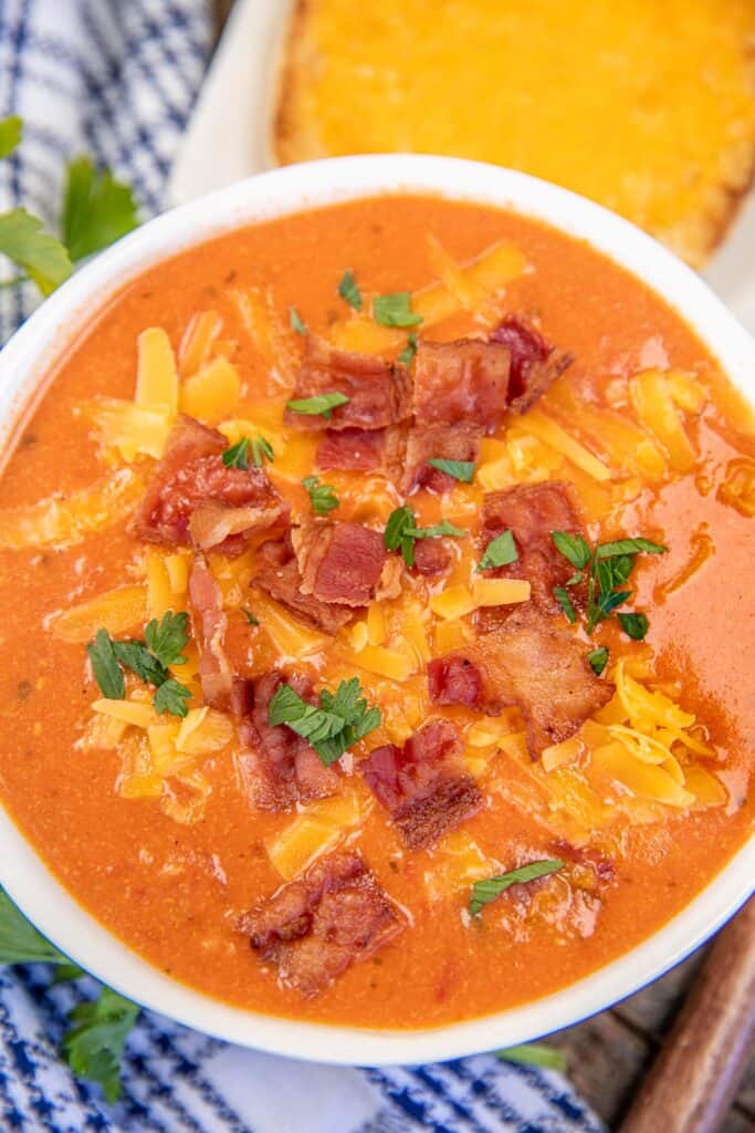 bowl of tomato soup topped with cheese and bacon