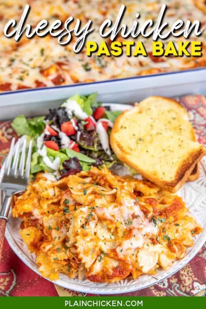 plate of cheesy chicken pasta, salad, and garlic bread with text overlay