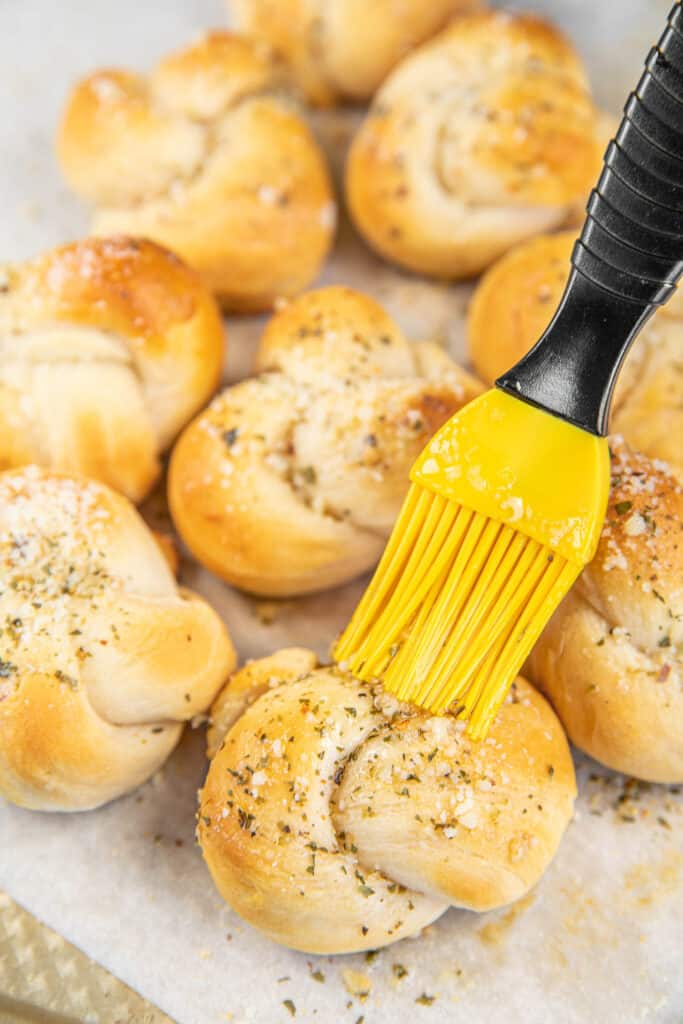 brushing garlic knots with butter