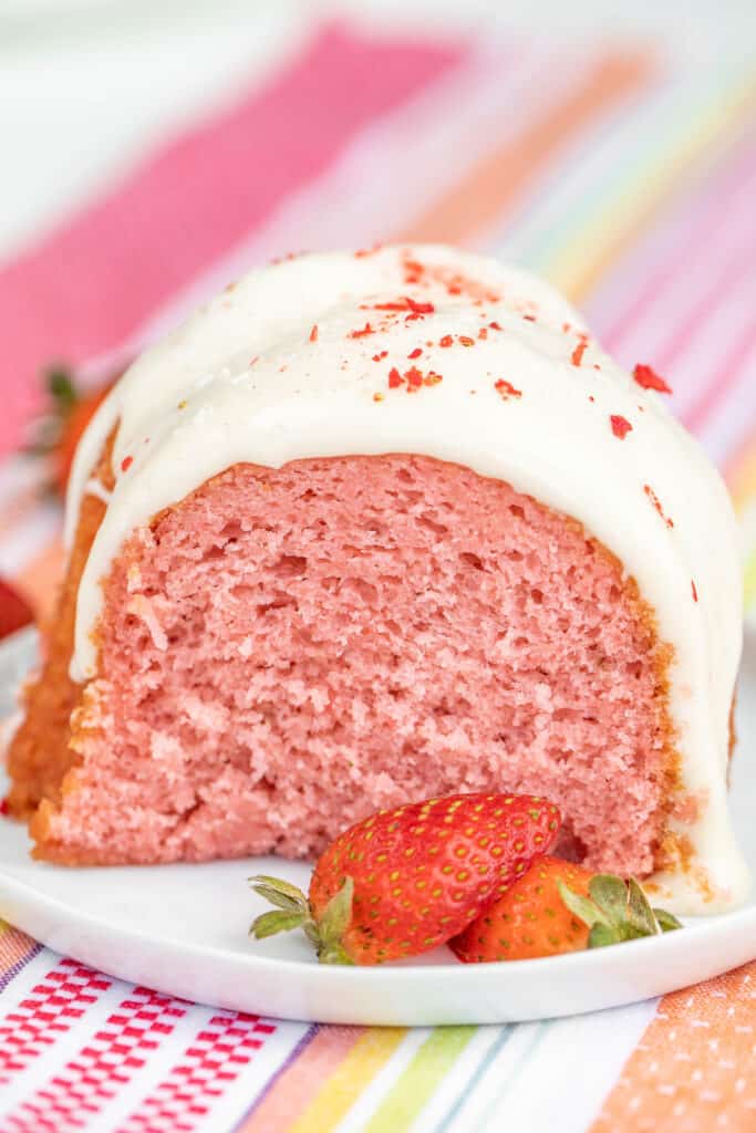 slice of strawberry cake topped with vanilla glaze