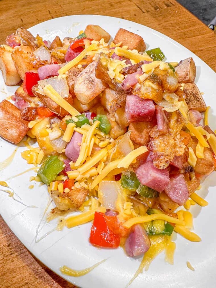 plate of hashbrowns with ham and peppers and cheese