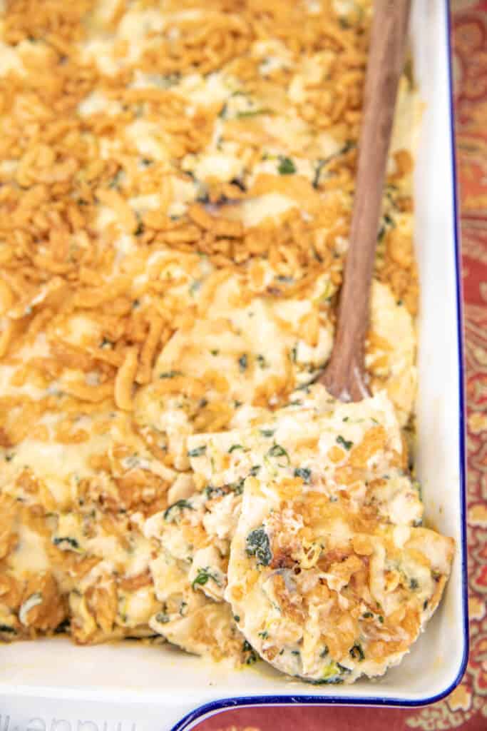 scooping chicken and spinach pieorgi casserole from baking dish