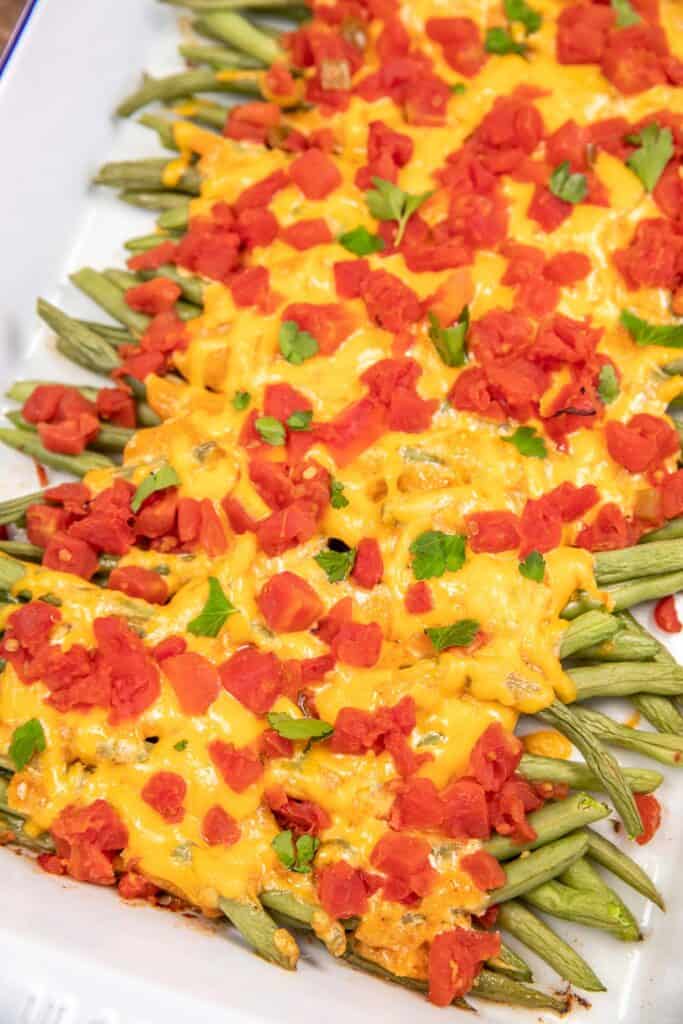 baking dish of green beans topped with cheese and rotel with text overlay