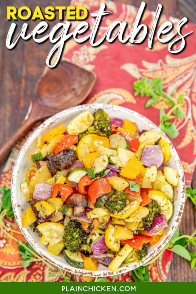 bowl of roasted vegetables on a table with a wooden spoon with text overlay
