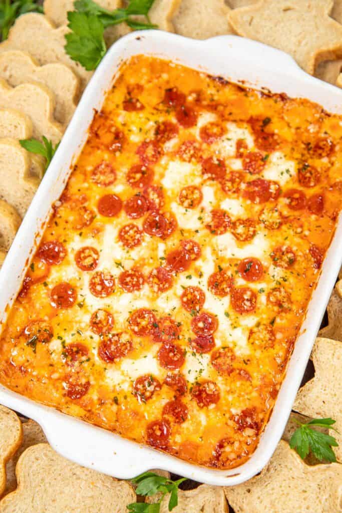 baking dish of pepperoni pizza dip surrounded by bread slices