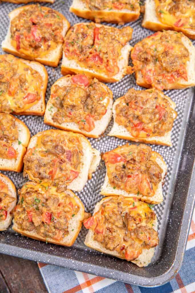 rotel sausage and cheese toasts on a baking sheet