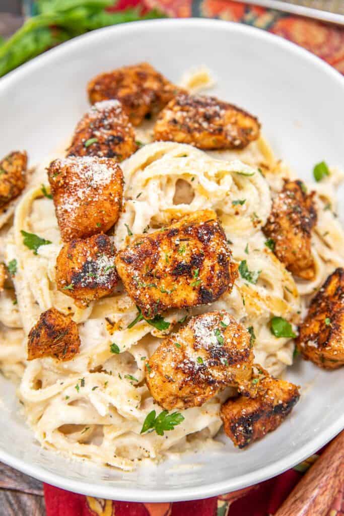 bowl of fettuccine alfredo with chicken with text overlay