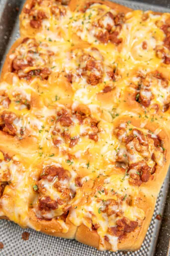 chili in bread bowls on a baking sheet topped with cheese