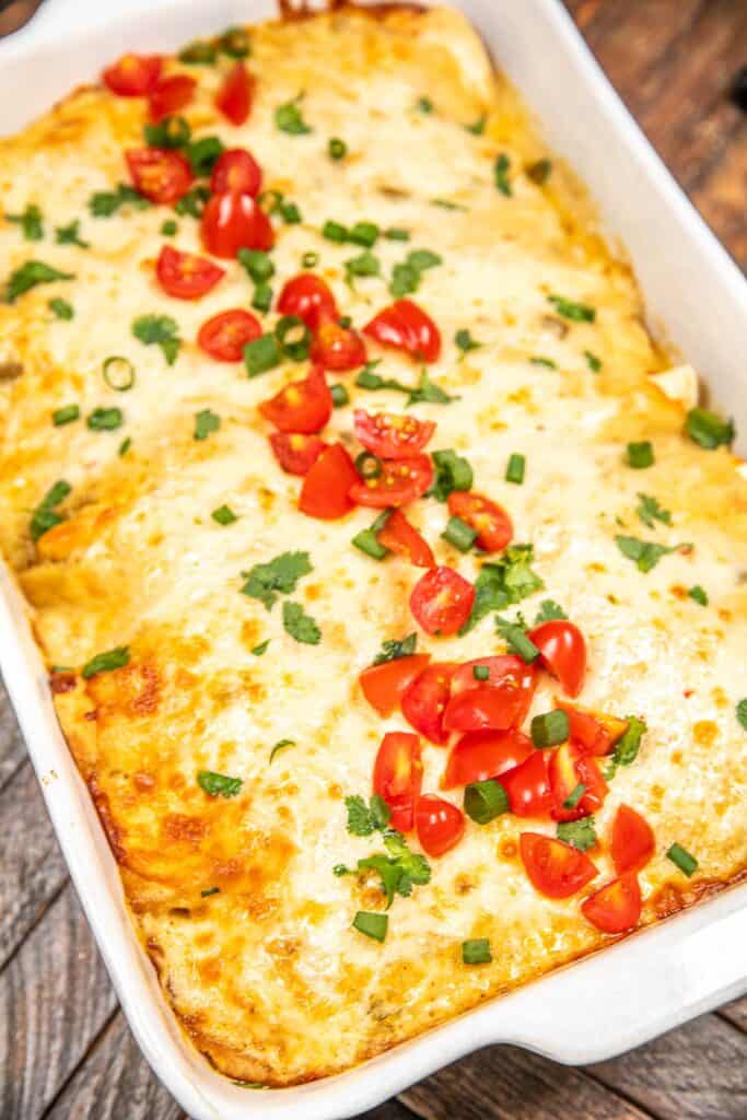 baking dish of breakfast enchiladas on a wooden table