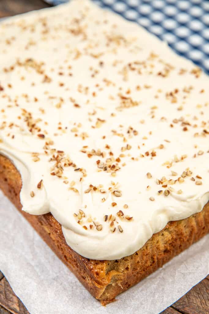 banana cake topped with cream cheese frosting and pecans